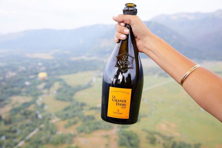 hand holding wine bottle with hills in background
